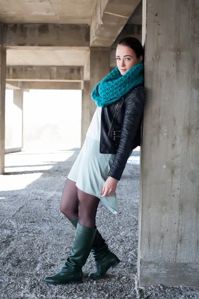 Девушка в кожаной куртке стоит бетонных конструкций — стоковое фото