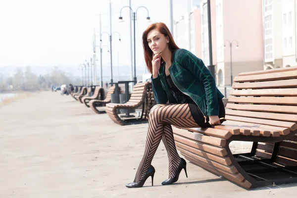 Zakenvrouw zittend op een bankje in de stad — Stockfoto