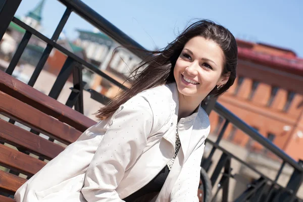 Young business woman sitting on a bench in the city — Stock Photo, Image