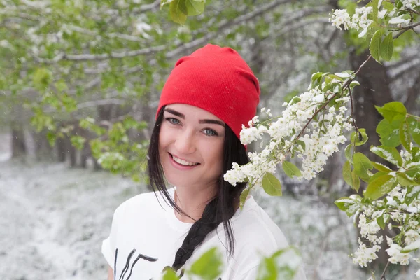 Chica en el jardín florecido disfruta de las nevadas —  Fotos de Stock