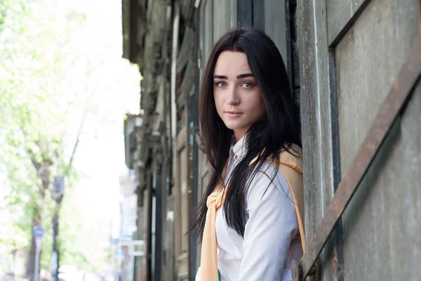 Portret van een jong meisje op een achtergrond van de oude blokhuis — Stockfoto