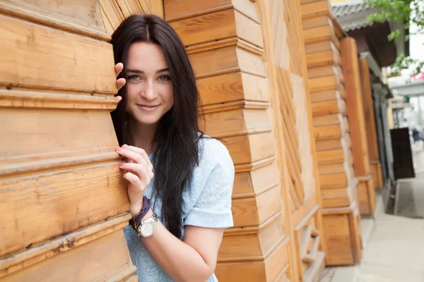 Retrato de una joven sobre un fondo de puertas de madera — Foto de Stock
