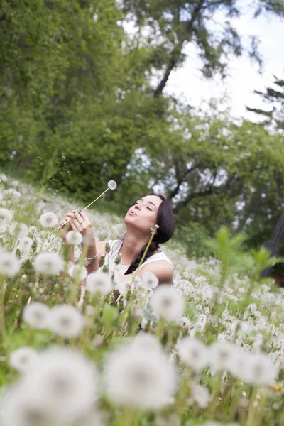 Meisje met een boeket van paardebloemen — Stockfoto