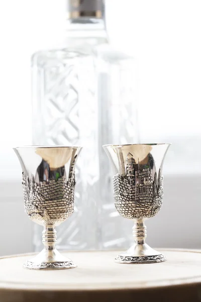 Vasos de plata sobre el fondo de una botella de vodka — Foto de Stock