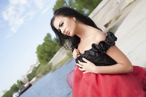 Девушка в красном платье на берегу реки — стоковое фото