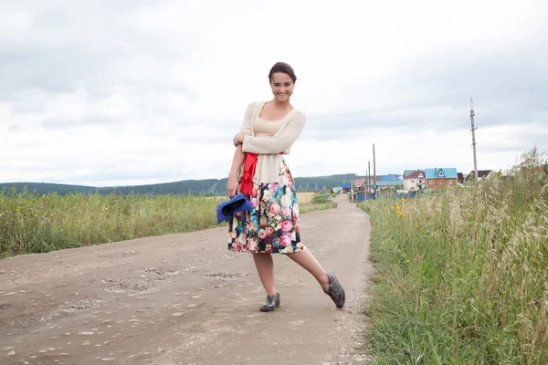 Girl in galoshes on a country road — Stock Photo, Image