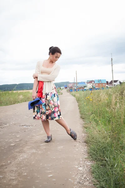 Fille en galoches sur une route de campagne — Photo