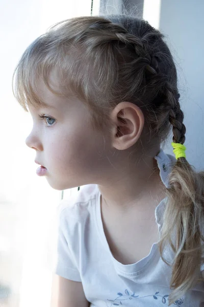 Küçük Kız Pencere Eşiğinde Oturur Pencereden Dışarı Bakar — Stok fotoğraf