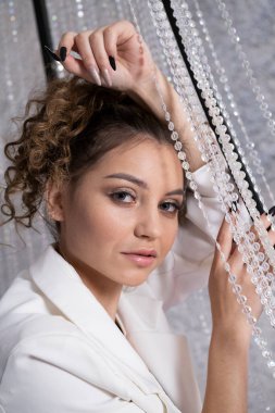 Beyaz elbiseli ve gece makyajlı bir kız.