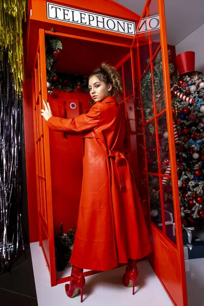 Kırmızı Deri Ceketli Telefon Kulübesinde Yüksek Çizmeli Genç Bir Kız — Stok fotoğraf