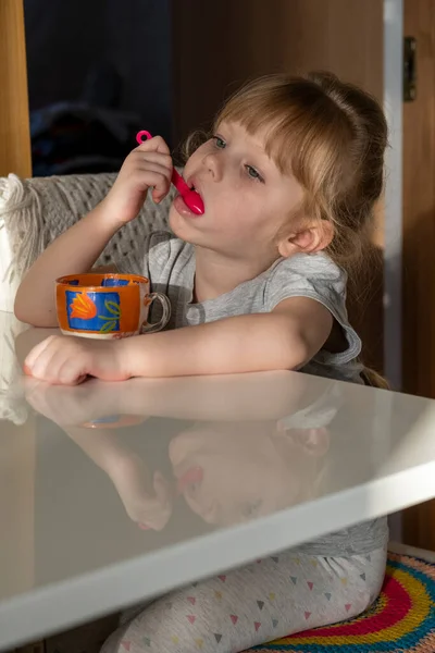 Kız Masaya Oturur Bir Kupadan Dondurma Yer — Stok fotoğraf