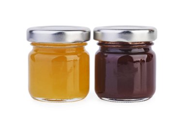 Farklı reçelli iki cam kavanoz beyaz arkaplanda izole edilmiş.