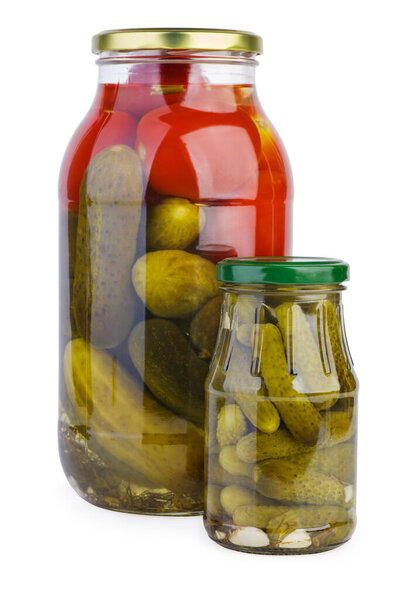 Glass jars with pickled tomatoes and cucumbers over the white background