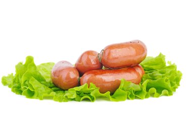 Beyaz arka planda izole edilmiş yeşil marul yaprağında ızgara sosisler.