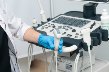 Algılayıcı yakın plan ultrason cihazı. Ultrason cihazının, ultrasonun arka planında, doktorun elinde bulunan sensörü..