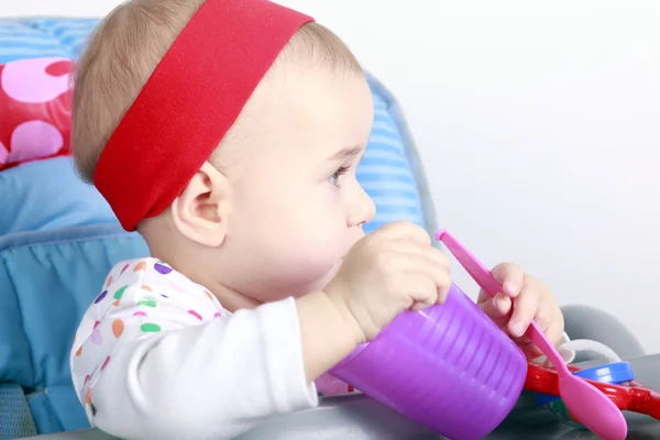 Baby with cup and spoon — Stock Photo, Image