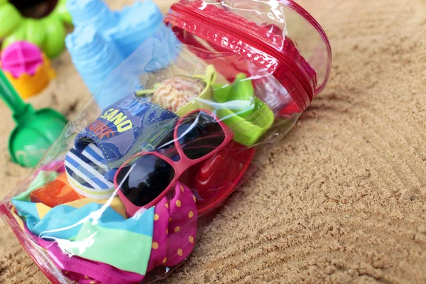 A homokban kis utazó táska Stock Kép