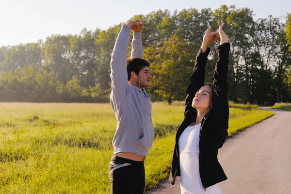 Paar doen stretching oefening na het joggen — Stockfoto