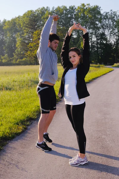 Couple doing stretching exercise after jogging — Stock Photo, Image