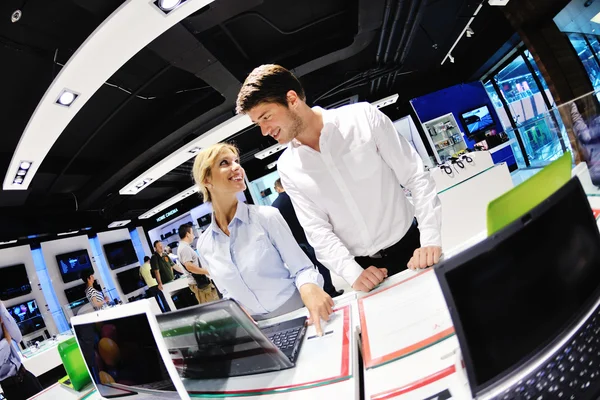 Pareja joven en tienda de electrónica de consumo — Foto de Stock