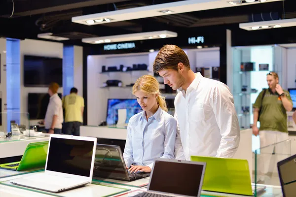 Pareja joven en tienda de electrónica de consumo — Foto de Stock