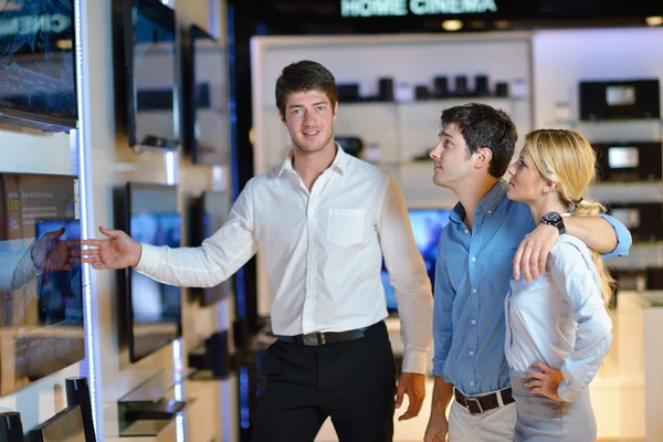 Pareja joven en tienda de electrónica de consumo — Foto de Stock