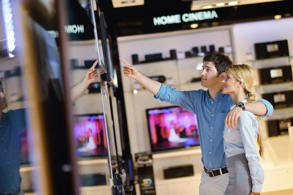 Pareja joven en tienda de electrónica de consumo — Foto de Stock