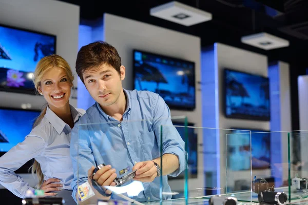 Pareja joven en tienda de electrónica de consumo — Foto de Stock