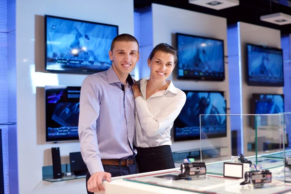 Pareja joven en tienda de electrónica de consumo — Foto de Stock