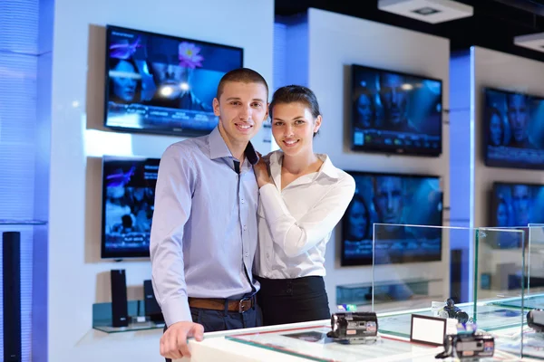 Pareja joven en tienda de electrónica de consumo — Foto de Stock