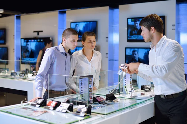 Pareja joven en tienda de electrónica de consumo — Foto de Stock