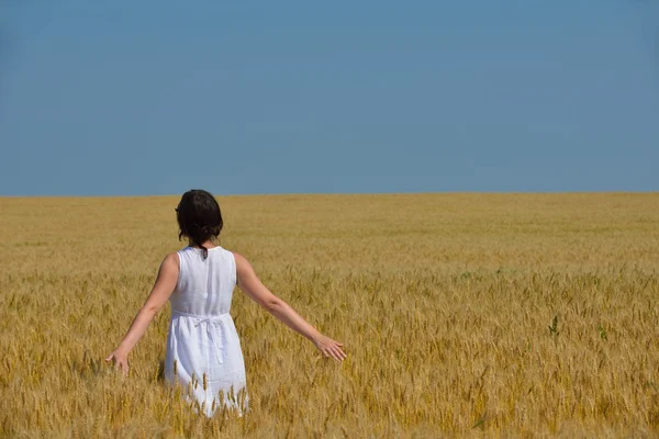 Junge Frau im Weizenfeld im Sommer — Stockfoto