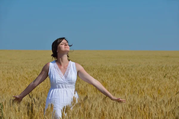 Junge Frau im Weizenfeld im Sommer — Stockfoto