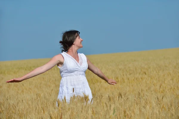 Junge Frau im Weizenfeld im Sommer — Stockfoto