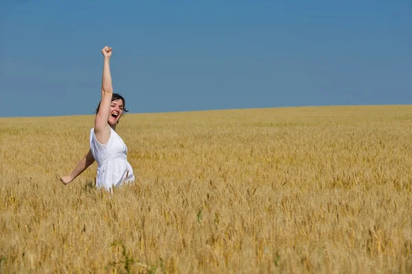 Junge Frau im Weizenfeld im Sommer — Stockfoto