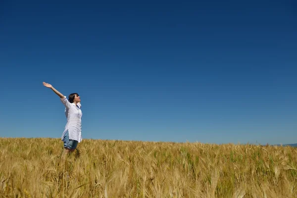 Junge Frau im Weizenfeld im Sommer — Stockfoto