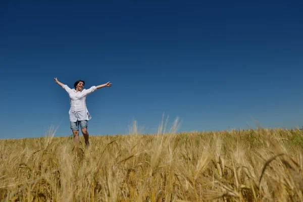 Young woman in wheat field at summer — Stock Photo, Image