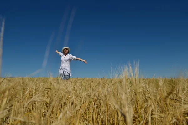 Junge Frau im Weizenfeld im Sommer — Stockfoto