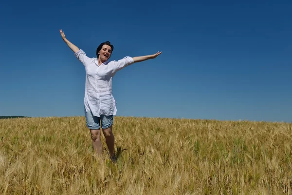 Mujer joven en el campo de trigo en verano —  Fotos de Stock