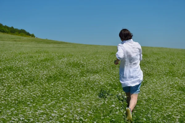 Jeune femme heureuse dans le champ vert — Photo