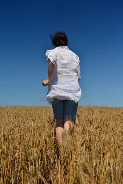 Jonge vrouw in tarweveld in de zomer — Stockfoto