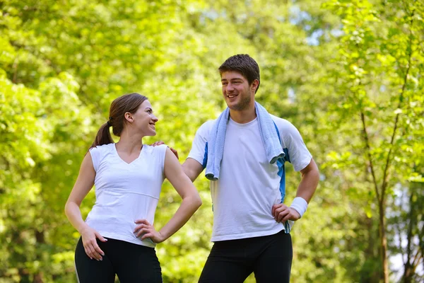 Casal fazendo exercício de alongamento após correr — Fotografia de Stock