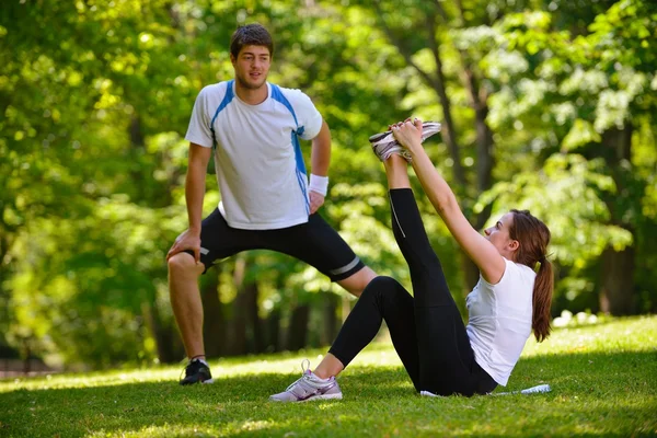 Coppia facendo esercizio di stretching dopo il jogging — Foto Stock