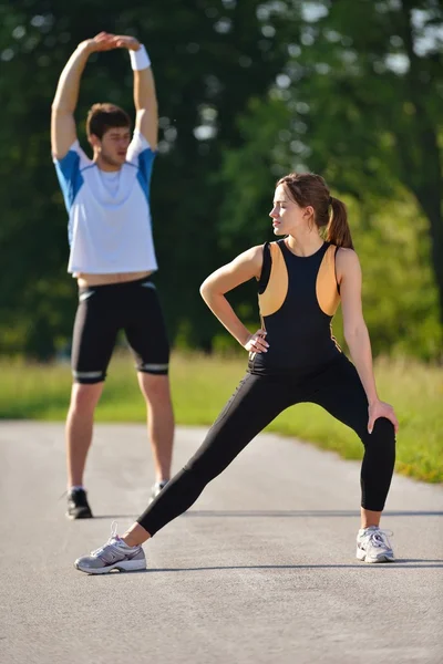 Par som stretchar efter jogging — Stockfoto