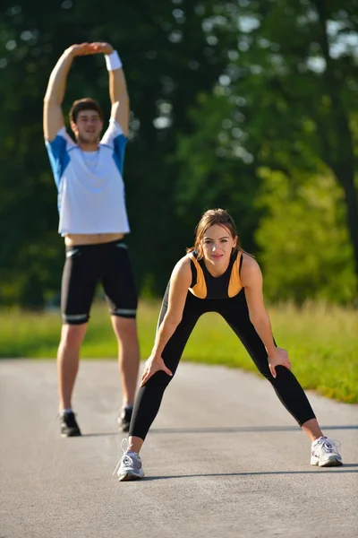 Coppia facendo esercizio di stretching dopo il jogging — Foto Stock