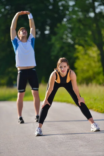 Couple faisant de l'exercice d'étirement après le jogging — Photo