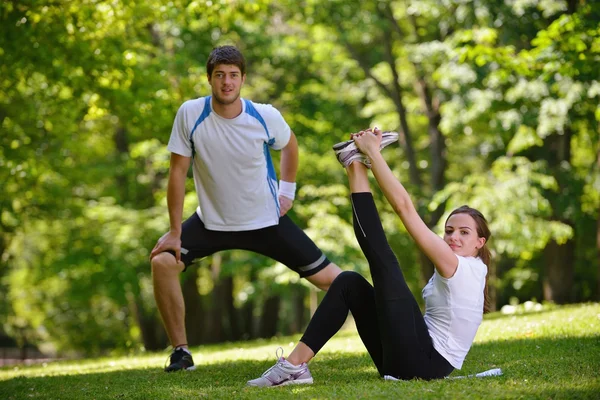 Couple doing stretching exercise after jogging Stock Picture