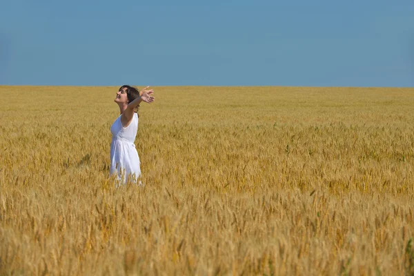 Young woman in wheat field at summer — Stock Photo, Image