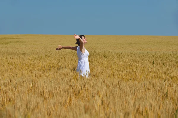 Junge Frau im Weizenfeld im Sommer — Stockfoto