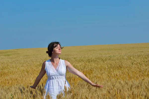 Mujer joven en el campo de trigo en verano —  Fotos de Stock